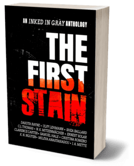 3D render of the book 'The First Stain,' an Inked in Gray anthology. The cover features a bold, dramatic design with the title 'The First Stain' in large, white block letters against a black background. The word 'Stain' is highlighted in a distressed red font, giving the appearance of blood or paint splatter. Above the title, the subtitle 'An Inked in Gray Anthology' is written in smaller white text. The names of the contributing authors are listed at the bottom in white text. The overall design is stark and intense, evoking themes of horror, mystery, or crime.