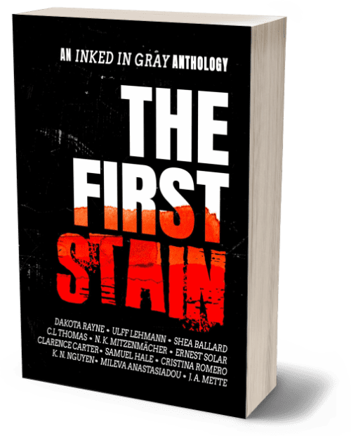3D render of the book 'The First Stain,' an Inked in Gray anthology. The cover features a bold, dramatic design with the title 'The First Stain' in large, white block letters against a black background. The word 'Stain' is highlighted in a distressed red font, giving the appearance of blood or paint splatter. Above the title, the subtitle 'An Inked in Gray Anthology' is written in smaller white text. The names of the contributing authors are listed at the bottom in white text. The overall design is stark and intense, evoking themes of horror, mystery, or crime.